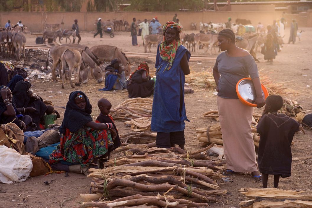 NIGER. Ayorou. Day before the Sunday market Tuareg slaves, some with anklets, in discussion with a Hausa vendor. 2005.